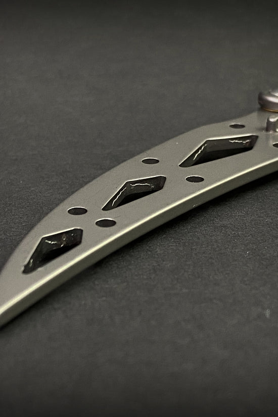 Guild Arms butterfly knife trainer for beginners with stainless steel handle on black surface