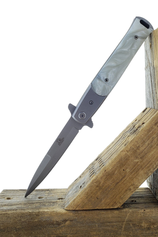 Falcon White Spring Assisted Pocket Knife with sleek design and durable materials on a wooden surface